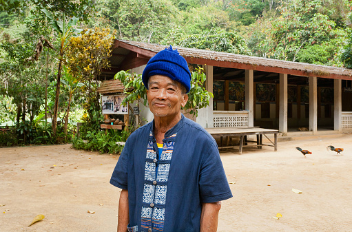 Chiang Mai, Thailand - February 24, 2016: Elderly man with smiley face living in taditional thai village with farmstay on February 24, 2016. Chiang Mai was former capital of the Kingdom of Lanna from 13th century