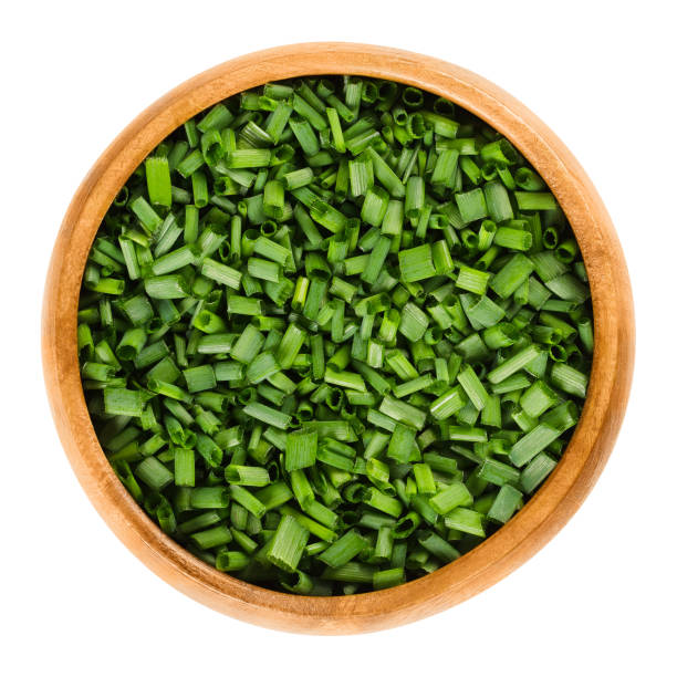 istock Chopped chives in wooden bowl over white 655178452