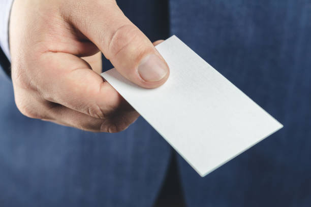 close-up of business man in blue suit holds white blank business card in the hand. - symbol communication business card men imagens e fotografias de stock