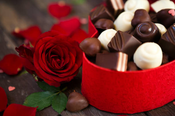 istock Chocolates in heart shaped box and red roses background- Mother’s Day 655182868
