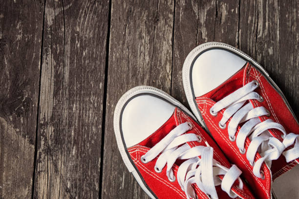 istock red sneakers on wooden background.Toned image 655185602