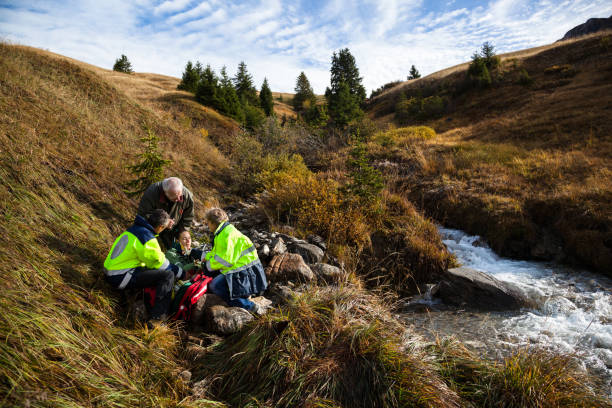 injured girl tended by swiss mountain rescue while concerned grandfather watches on - mountain drop europe switzerland imagens e fotografias de stock