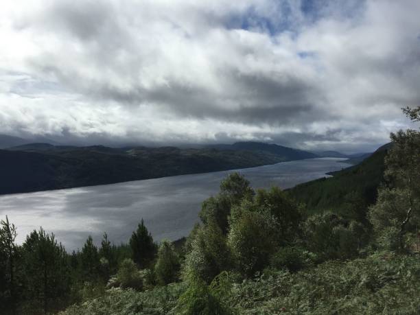 Loch Ness under a cloudy sky A view of Loch Ness in Scotland from high up on the Great Glen Way hiking trail, near Drumnadrochit, Scotland, UK. drumnadrochit stock pictures, royalty-free photos & images