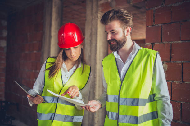 istock Teamwork of two engineers on a construction site with safety equipment 655224390
