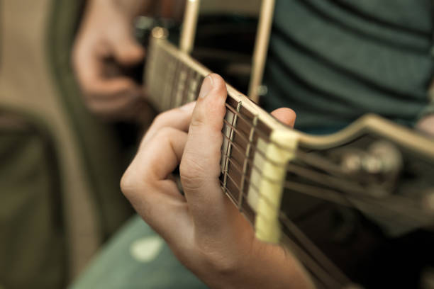 istock Musician's fingers on the strings of a guitar 655235292