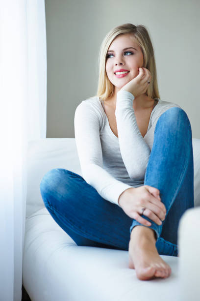 istock Contemplative young woman sitting on sofa 655242702