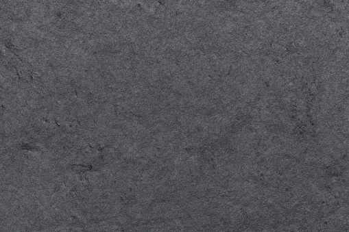 Dark gray background of natural slate. Texture black stone close up.