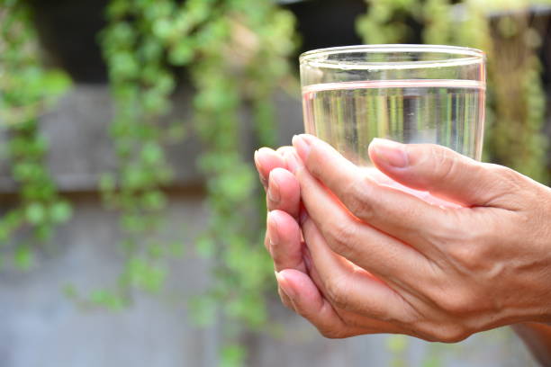 istock hands hold the glass and water in glass 655248780