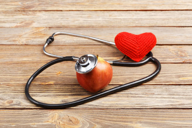 istock Apple, stethoscope and heart on wooden background 655251478