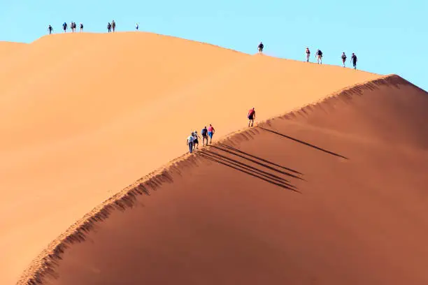 Photo of People climbing a dune in Sossusvlei Namibia