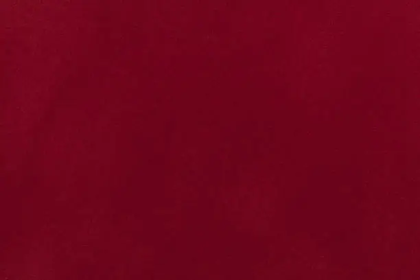 Dark red suede fabric closeup. Velvet texture background