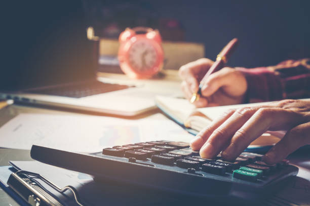 istock Businessman's hands with calculator at the office and Financial data analyzing  counting on wood desk 655266310