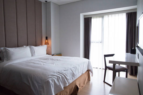 istock Hotel bedroom with double bed, table and TV set 655271734