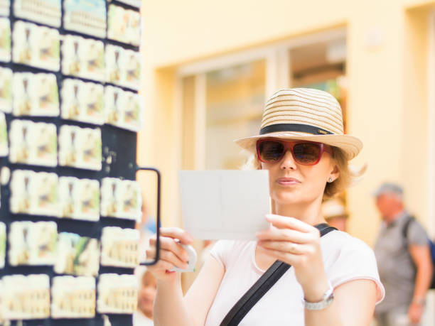 Tourist choosing postcard on the city