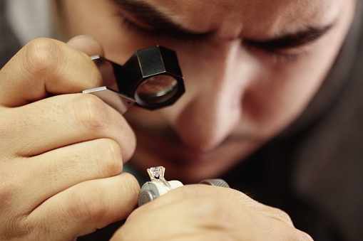 Jeweler repairing diamond ring in workshop