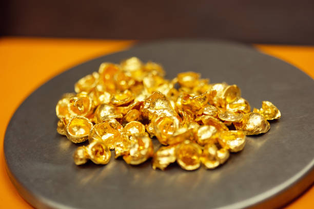 Raw gold in the pan ready to melt in the manufacturing process of jewelry made of gold. Pure, real gold on photo.