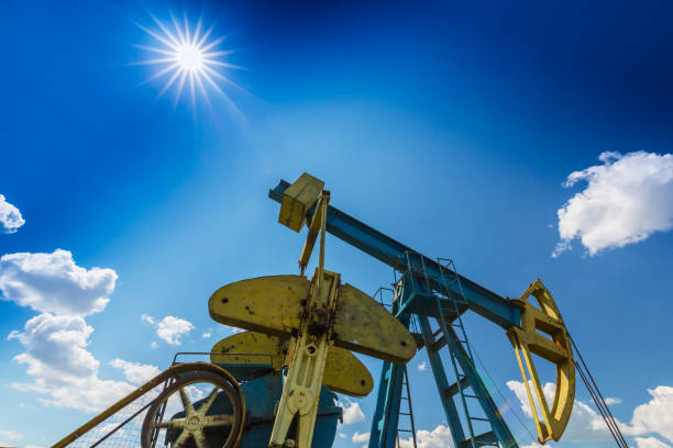istock Oil field with pump jack, profiled on blue sky with white clouds, on a sunny day 655284888