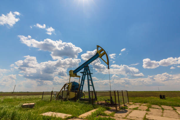 istock Oil field with pump jack, profiled on blue sky with white clouds, on a sunny day 655287288