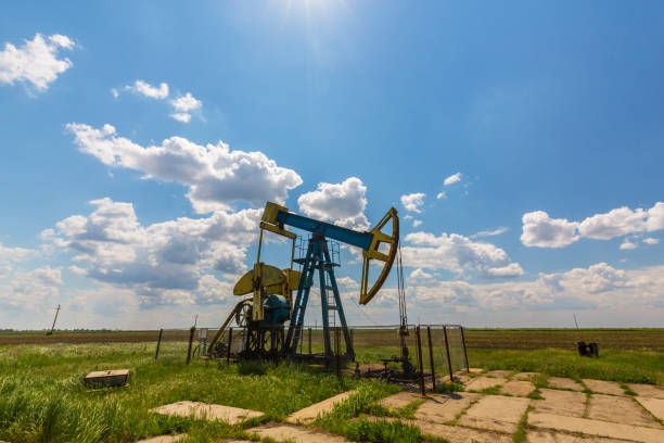 istock Oil field with pump jack, profiled on blue sky with white clouds, on a sunny day 655287292