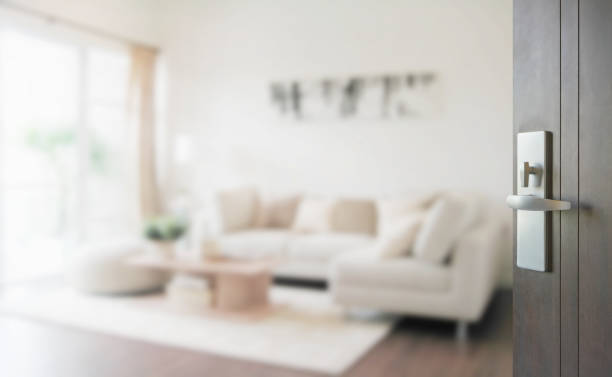 opened wooden door to modern living room interior stock photo