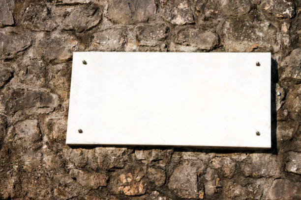 istock White marble sign. White marble sign on a stone wall. 655298794