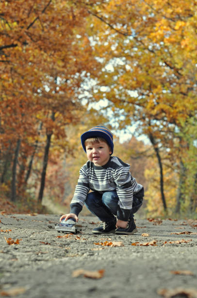 istock Boy play with car toy in park 655299596