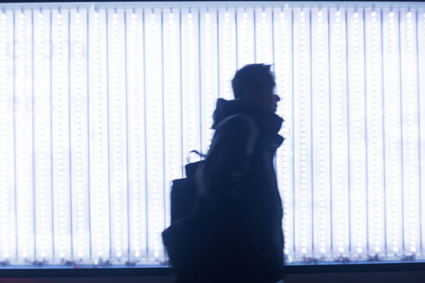 man walking in front of LED light