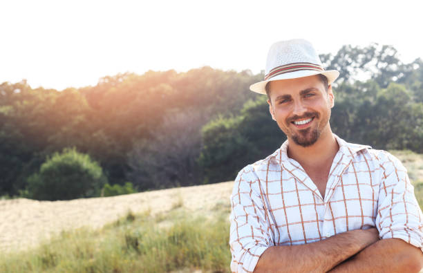 istock Smiling young man with hat standing arms crossed 655303484