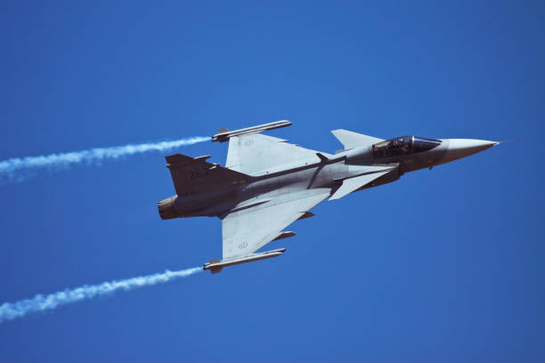Bangalore, Karnataka, India - 02/17/2017 :  Swedish JAS 39 Gripen flying pass the spectators at Aero India 2017 at Bangalore in India. Taken this picture when the aeroplane doing aerobatics over the crowd leaving a smoke line behind.