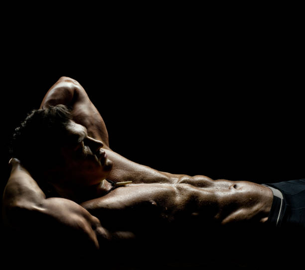 muscular sexy guy the very muscular sleeping sexy guy, lying on black background, naked  torso sleep bodybuilder stock pictures, royalty-free photos & images