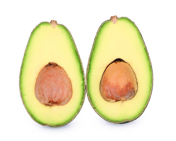 metà di avocado isolato sul bianco - avocado cross section vegetable seed foto e immagini stock