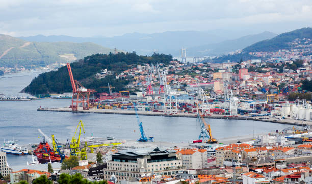 Aerial view on Vigo cargo seaport in sunny day part of town in back and bridge visible.