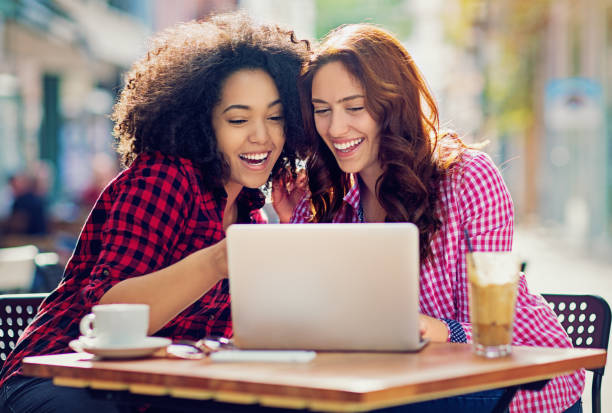 istock Two happy girls are browsing with their laptop 655367510