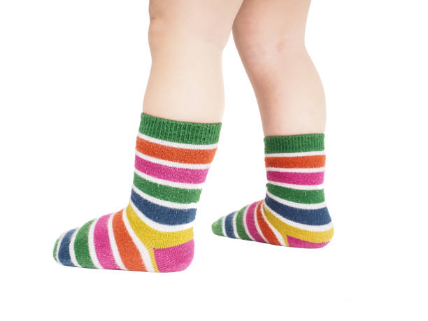 Toddler standing in striped socks and bare legs stock photo