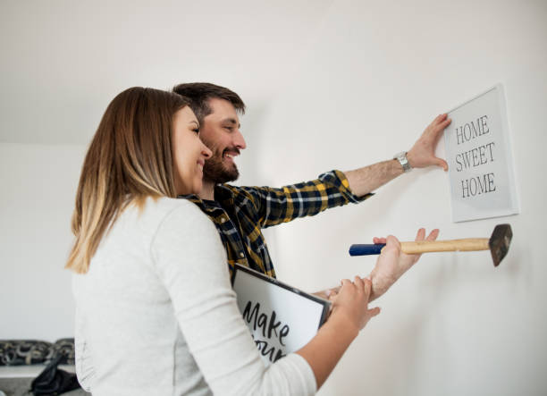 istock Couple hanging picture on wall 655371112