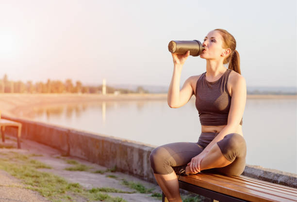 istock young girl drinks a protein cocktail from a schweeter after jogging 655377732