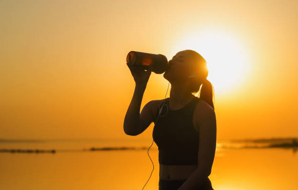 Silhouette of a young girl who drinks a protein cocktail