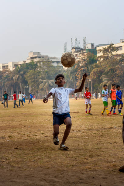 Group of children playing football at local football stadium located at South Mumbai, India
