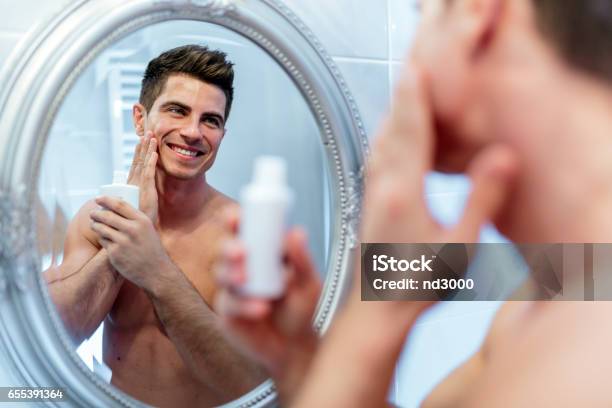 Healthy Positive Male Treating Sking With Lotion After Shaving Stock Photo - Download Image Now