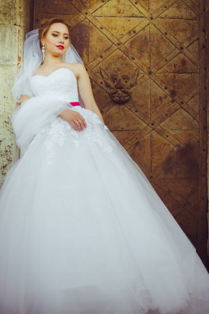 istock Beautiful bride walking near old castle before wedding ceremony 655392366