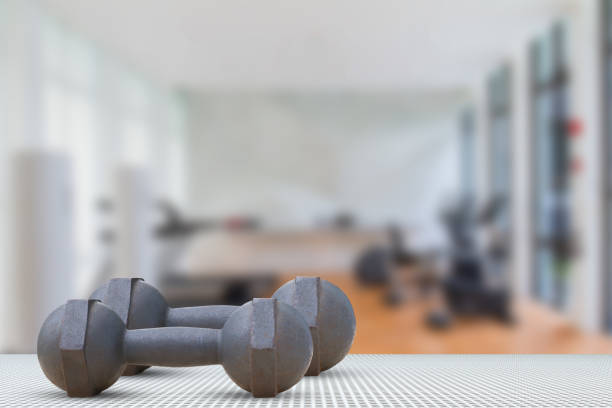 istock Dumbbells on aluminium texture floor on blurred gym background 655400824