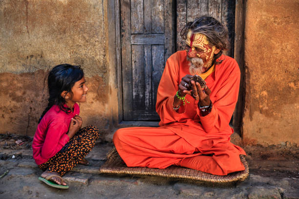 niña observando cómo sadhu haciendo su maquillaje - varanasi fotografías e imágenes de stock