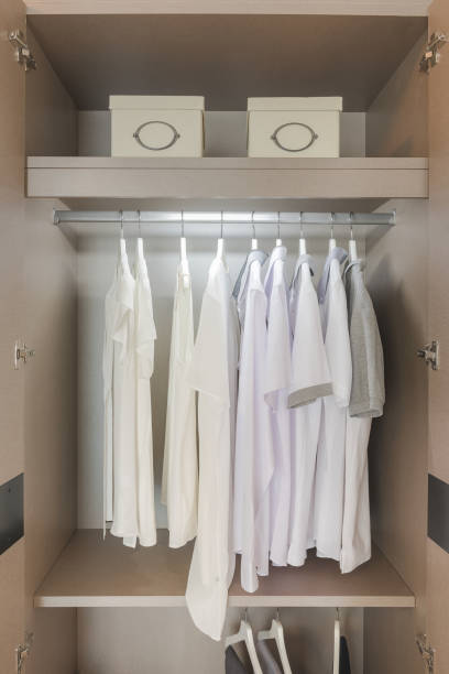 istock white shirts hanging on rail in wooden wardrobe 655424934