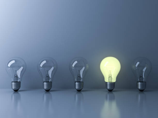 istock One glowing light bulb standing out from the unlit incandescent bulbs on blue background with reflection and shadow , individuality and different creative idea concepts 3D rendering 655449064