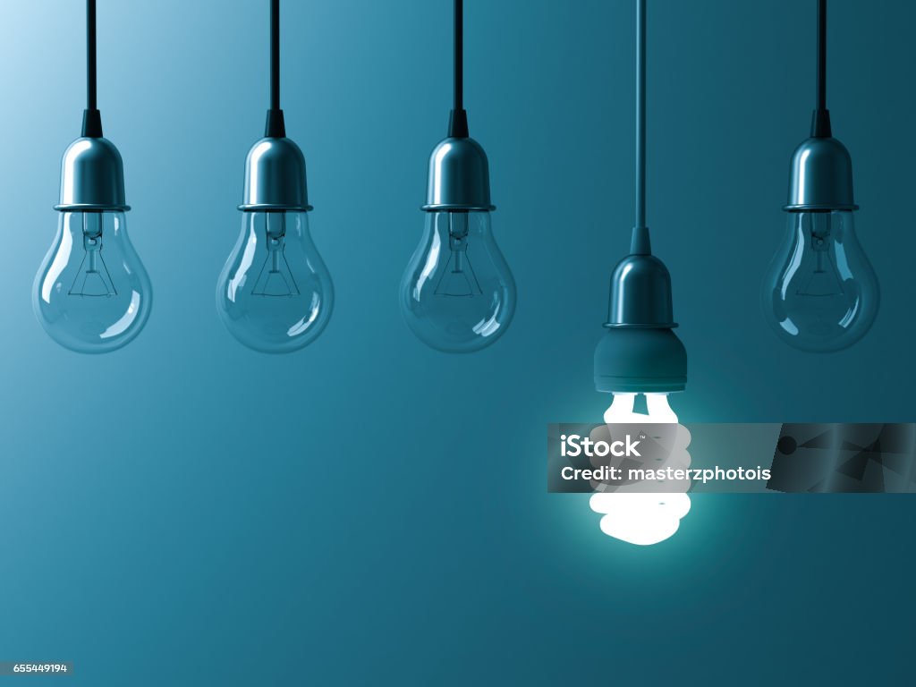 One hanging energy saving light bulb glowing different stand out from unlit incandescent bulbs with reflection on dark cyan background , leadership and different creative idea concept 3D rendering One hanging energy saving light bulb glowing different stand out from unlit incandescent bulbs with reflection on dark cyan background , leadership and different creative idea concept. 3D rendering. Standing Out From The Crowd Stock Photo