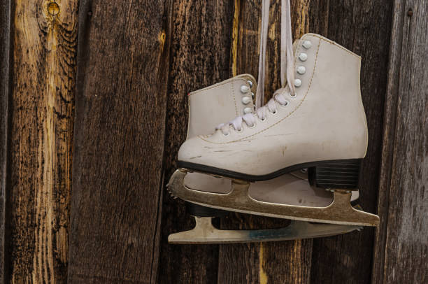 istock The old white skates hanging on nails on wooden background 655458852