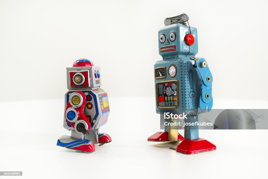 Pair of vintage tin toy robots isolated on white background Two vintage tin toy robots isolated on white background Robot Stock Photo
