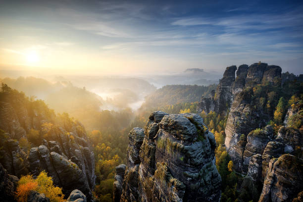 brumoso amanecer en bastei, suiza sajona, alemania - basteifelsen fotografías e imágenes de stock