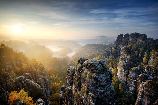 Beautiful panoramic view at sandstone rocks during foggy sunrise at Bastei, Saxon Switzerland, Germany