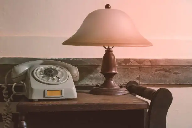 Photo of Vintage - Old  phone and  retro lamp on the desk